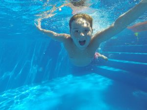 enfant qui nage dans une piscine d'un camping Aveyron